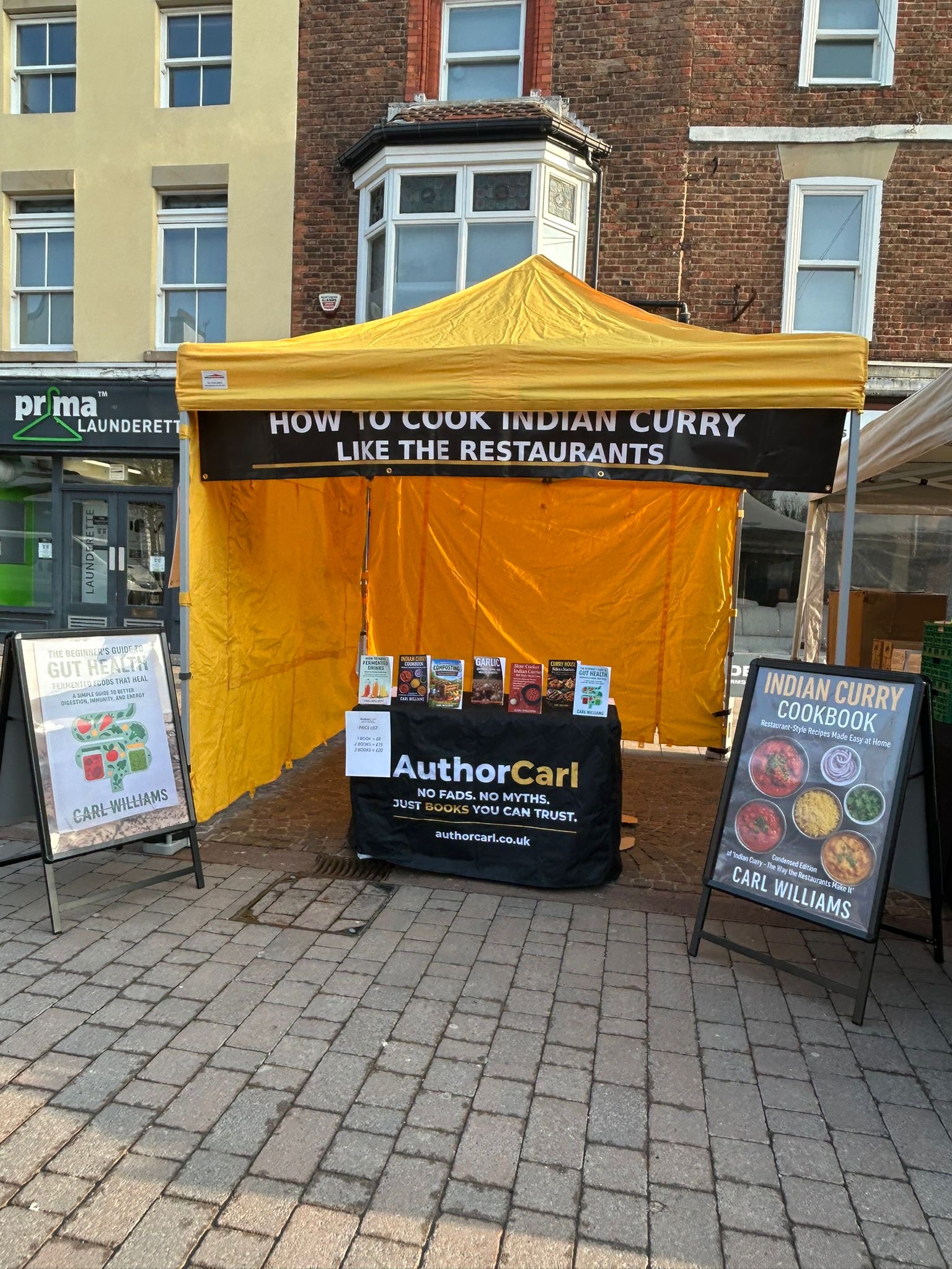 Author Carl stall at Ormskirk Market with yellow gazebo and books on display